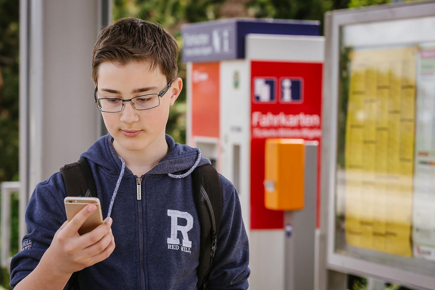 Das Bild zeigt einen Jungen mit Handy in der Hand an einem Bahnhof (© VRS / Smilla Dankert)