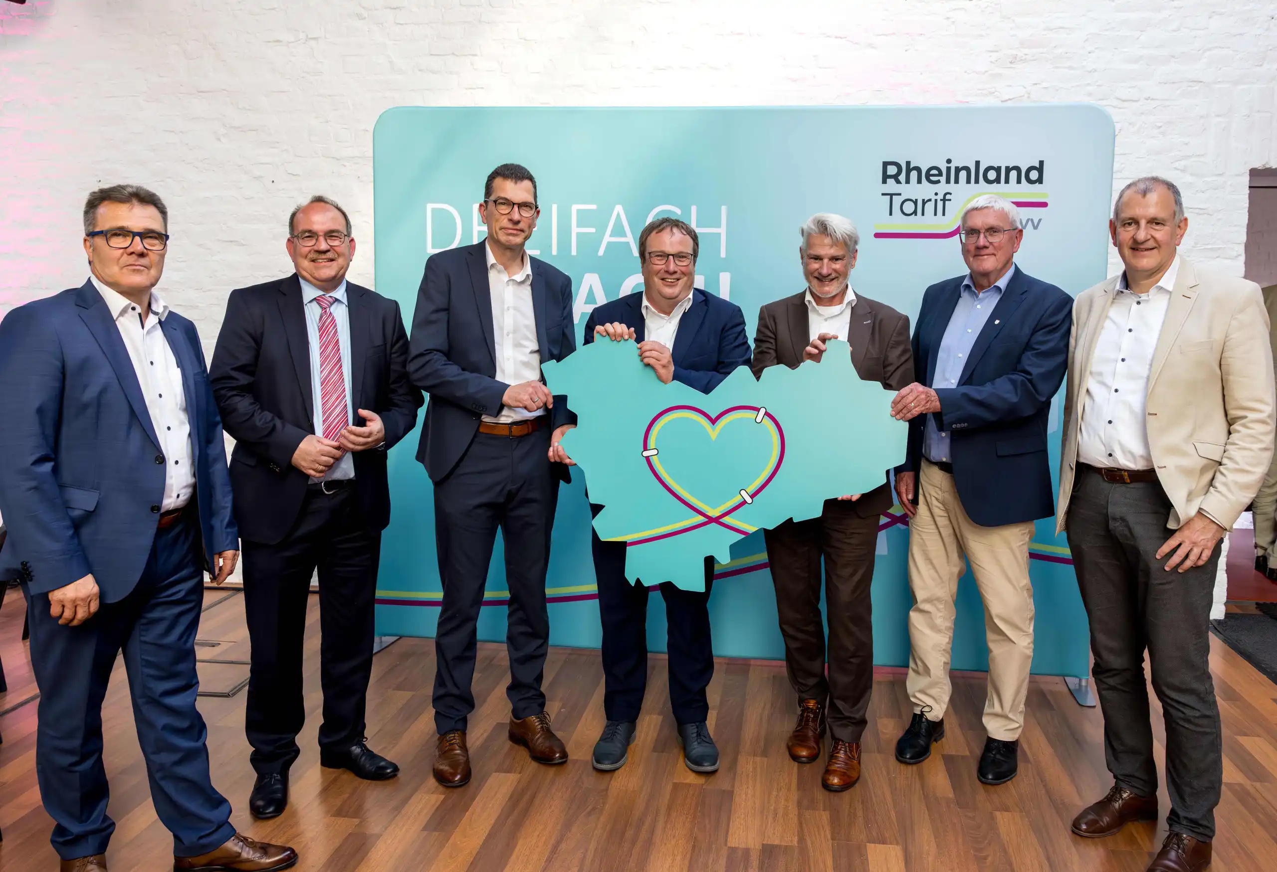 Das Bild zeigt v.l.: Volker Otto, Dr. Ralf Nolten, Hans-Peter Geulen, Minister Oliver Krischer, Michael Vogel, Sebastian Schuster und Joachim Adler mit einer Karte, die die Umrisse des neuen gemeinschaftlichen Tarifgebiets zeigt.