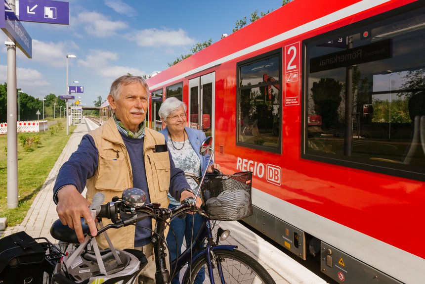 älteres Paar mit Fahrrädern am Bahnsteig mit RegionalBahn