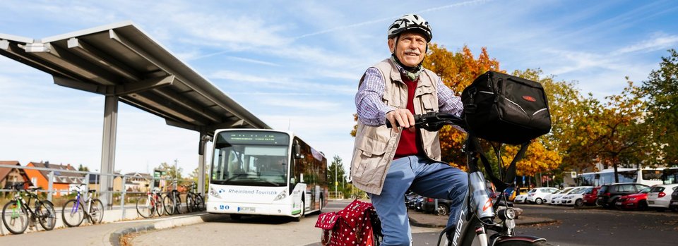 älterer Mann auf Fahrrad (Bushaltestelle)