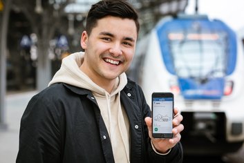 Junger Mann mit Handy am Kölner Hauptbahnhof
