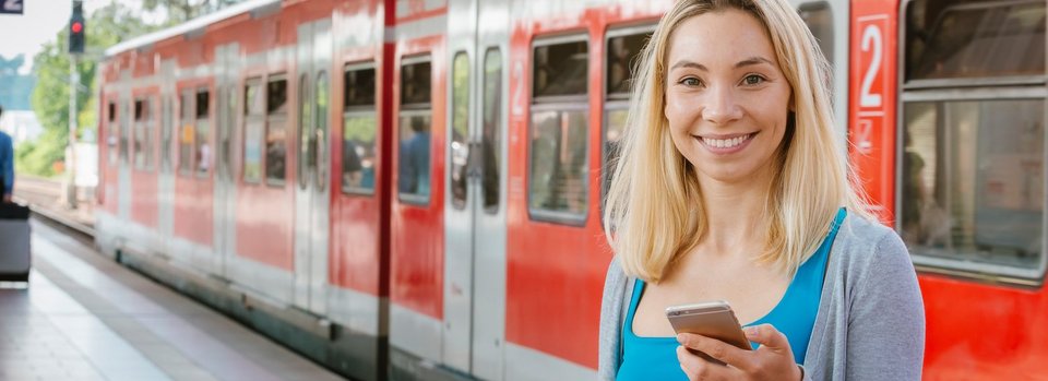 Junge Frau mit Handy am Bahnhof Junge Frau mit Handy am Bahnhof