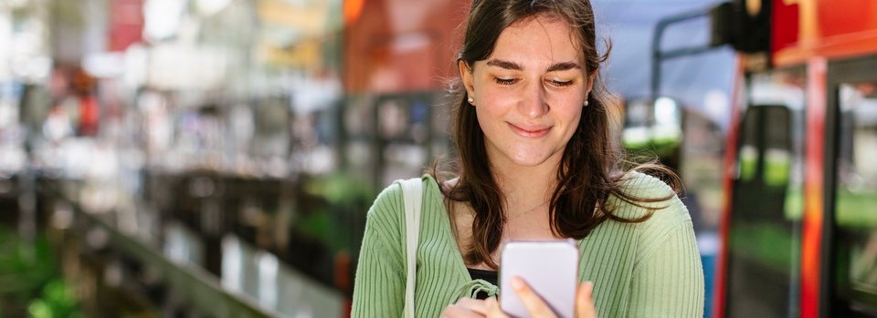 Junge Frau mit Handy an Stadtbahn-Haltestelle Junge Frau mit Handy an Stadtbahn-Haltestelle