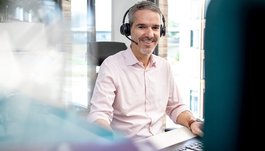 Mitarbeiter mit Telefon-Headset am Arbeitsplatz