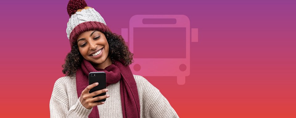 Frau mit Mütze schaut lachend ins Handy