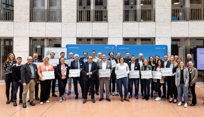 Eine große Gruppe hält Urkunden in der Hand