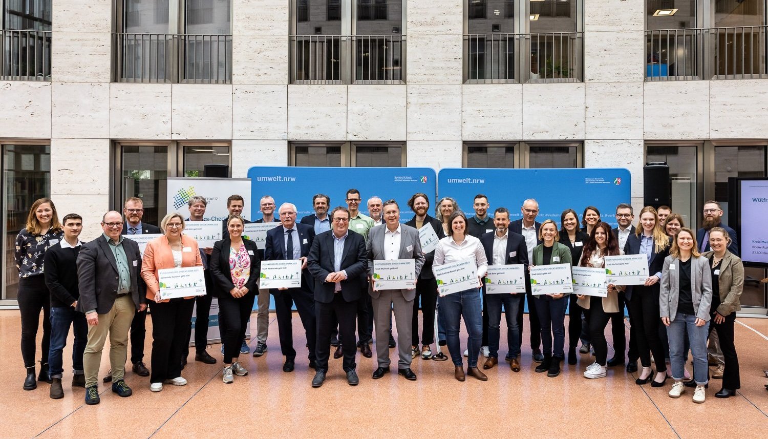 Eine große Gruppe hält Urkunden in der Hand