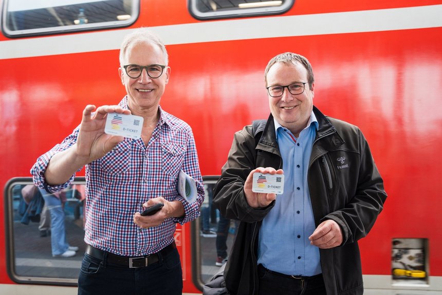 Landesverkehrsminister Oliver Krischer und Dr. Norbert Reinkober zeigen Deutschlandticket-Chipkarten