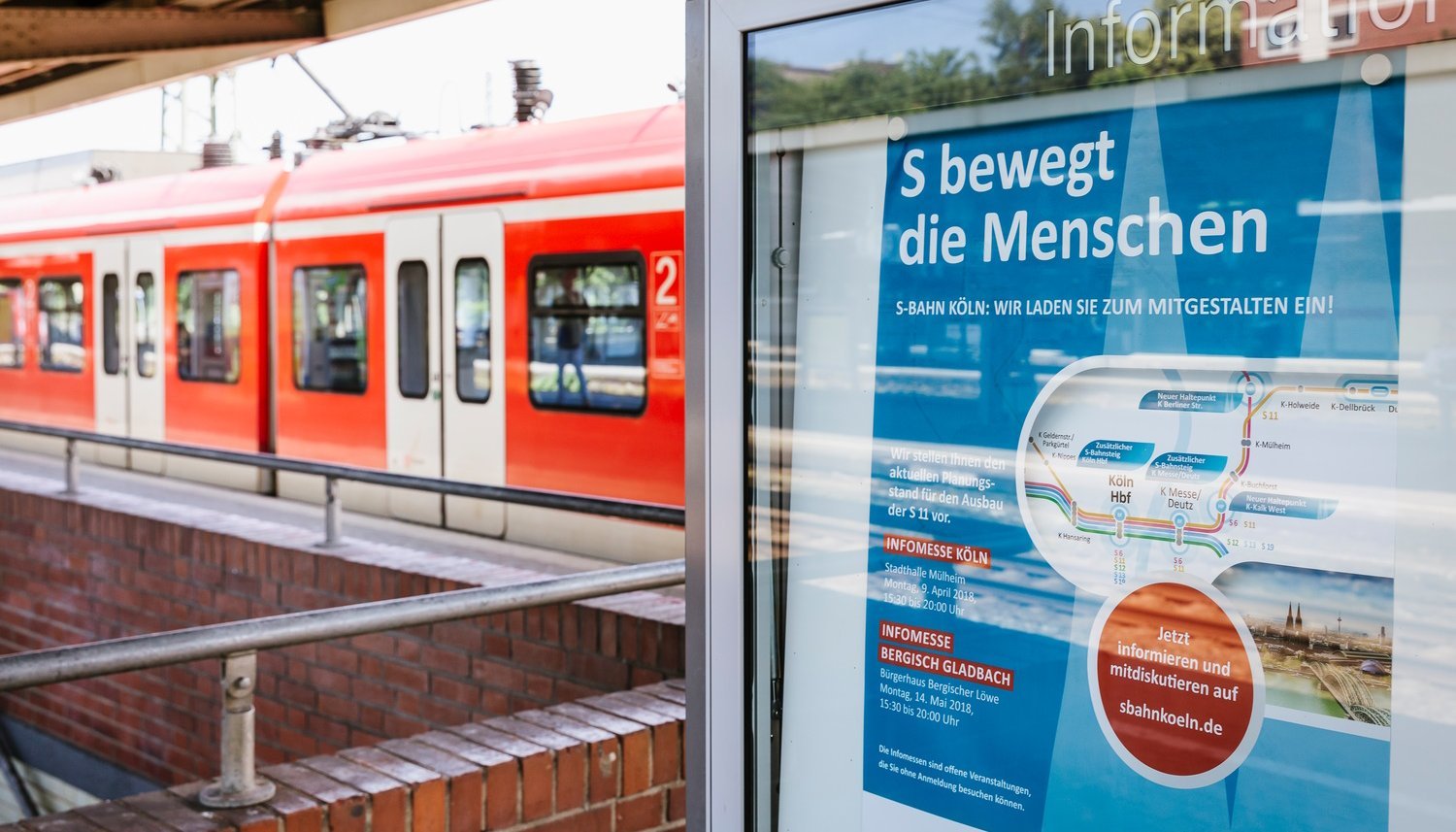 Ein Plakat am Bahnhof mit der Aufschrift: "S-Bahn Köln: Wir laden Sie zum mitgestalten ein"