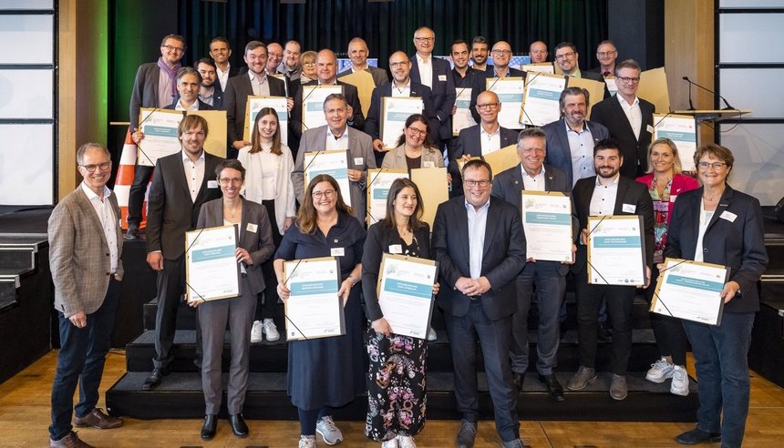 Eine große Gruppe von Personen die Urkunden halten.