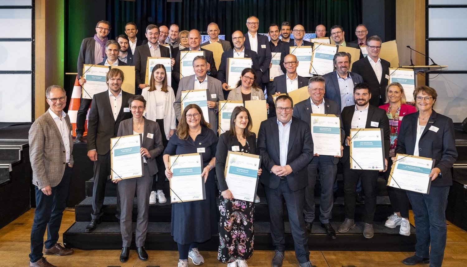 Eine große Gruppe von Personen die Urkunden halten.