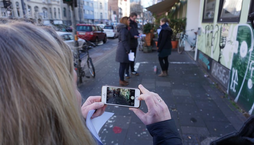 Mehrere Personen dokumentieren den Zustand eines Bürgersteigs