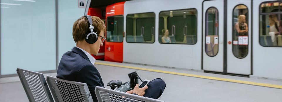 Fahrgast mit Kopfhörer auf Stadtbahn wartend Fahrgast mit Kopfhörer auf Stadtbahn wartend