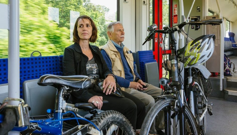 Zwei Personen mit ihren Fahrrädern im Fahrradabteil