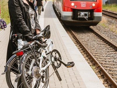 Kundin mit Faltrad am Bahnsteig